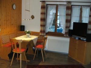 a dining room with a table and chairs and a television at Haus Aretz in Feldberg