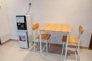 a table and two chairs next to a refrigerator at Ricefield View 2 BR villa near Canggu in Dalung