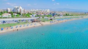 a beach with umbrellas and people in the water at Caesar resort 2 bedrooms Cornelius in Vrysoules
