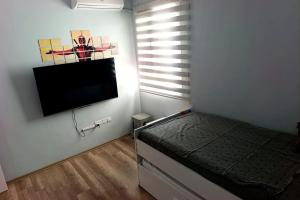 a bedroom with a bed and a flat screen tv at Caesar resort 2 bedrooms Cornelius in Vrysoules
