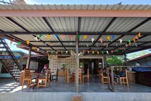 a patio with a table and chairs and flags at Smilingface guesthouse in Sukhothai