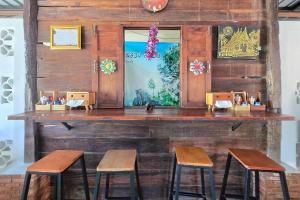 a counter with stools in a room with wooden walls at Smilingface guesthouse in Sukhothai