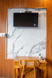 a wooden table with a television on a wall at Ricefield View 2 BR villa near Canggu in Dalung