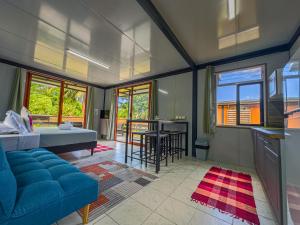 a living room with a blue couch and a table at Tekehani Lodge in Araito