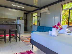 a living room with a large bed and a kitchen at Tekehani Lodge in Araito +44 photos