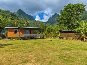 a house in a field with mountains in the background at Tekehani Lodge in Araito