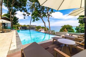 an infinity pool at a resort with tables and umbrellas at Anthiya Seaview Villa Hotel Phuket in Kata Beach +68 photos