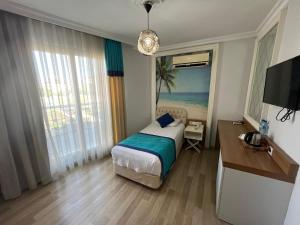a bedroom with a bed and a desk and a television at River suite hotel in Manavgat