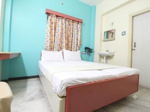 a bedroom with a bed with a window and a sink at Sri Ganapathy Lodge in Coimbatore +3 photos
