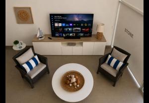 a living room with a table and two chairs and a tv at Ocean View Apartment Beach Pools Pier & Lift in Paracas