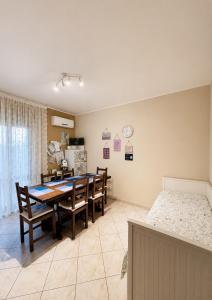 a dining room with a table and chairs and a bed at Villa Romano in Nicolosi
