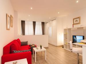 sala de estar con sofá rojo y mesa en Apartments Las Canteras Beach LM3, en Las Palmas de Gran Canaria