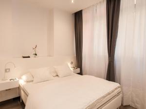 Un dormitorio blanco con una cama blanca y una ventana en Apartments Las Canteras Beach LM3, en Las Palmas de Gran Canaria