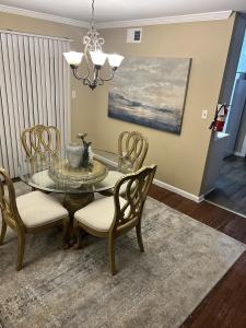 a dining room with a glass table and chairs at The Haven at Mariama House in Upper Marlboro +27 photos