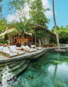a swimming pool with lounge chairs and a resort at Ulaman Eco Luxury Resort in Tabanan