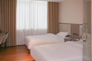 a hotel room with two beds and a window at Shenzhen Green Oasis Hotel, Baoan in Bao'an