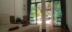 a bedroom with a bed and a sliding glass door at water fall resort soksan in Phumĭ Kaôh Rŏng