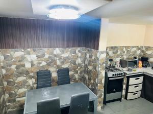 a kitchen with a stove and a table and chairs at BaseCotopaxi Mini depart 5p free parking in Latacunga