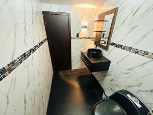a bathroom with a toilet and a sink and a mirror at BaseCotopaxi Mini depart 5p free parking in Latacunga +11 photos