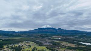 a snow capped mountain in the middle of a valley at BaseCotopaxi Mini depart 5p free parking in Latacunga