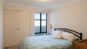 a bedroom with a bed and a window at Beachside on Kent in Busselton