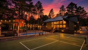 a house with a tennis court in front of it at Creek,Pool,Playhouse celebration estate, sleeps 21 in Broken Bow