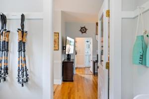 a hallway with skis on the wall and a refrigerator at Acadia View Cottage Peaceful, Pet Friendly, Fire Pit, Near Peaks and Echo Lake in Hall Quarry