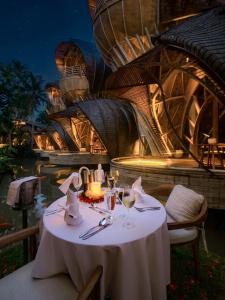 a table with a white table cloth on top at Ulaman Eco Luxury Resort in Tabanan