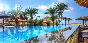 basen w ośrodku wypoczynkowym z palmami w obiekcie JHotelResorts w mieście Ad-Damur