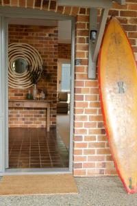 a surfboard is leaning against a brick wall at Edgewater on Quindalup Beachfront in Quindalup