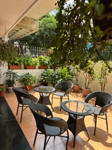 a patio with tables and chairs and potted plants at The Neem in New Delhi