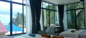 a bedroom with large windows and a view of the ocean at water fall resort soksan in Phumĭ Kaôh Rŏng +63 photos