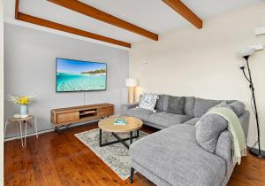 a living room with a couch and a table at Tabone on Jones in Kiama Downs