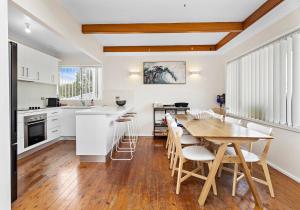 a kitchen and dining room with a table and chairs at Tabone on Jones in Kiama Downs