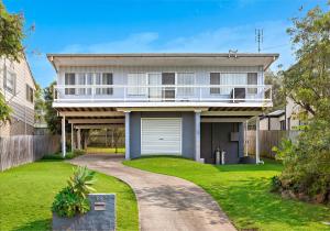 a house with a balcony and a driveway at Tabone on Jones in Kiama Downs