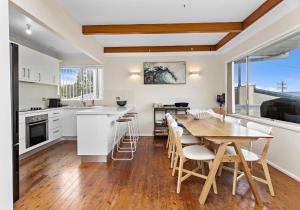 a kitchen and dining room with a table and chairs at Tabone on Jones in Kiama Downs +6 photos