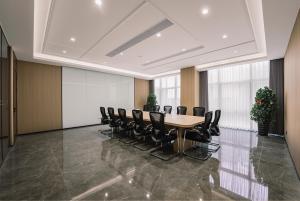 a conference room with a table and black chairs at 义乌雅寓酒店国际商贸城六区店 in Yiwu