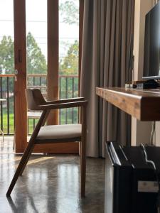 a chair sitting in front of a desk with a computer at Glai boutique hotel in Ban Cha Prong