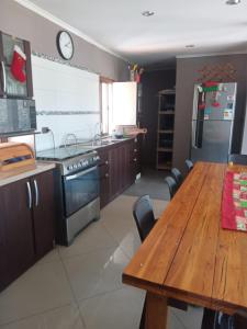 a kitchen with a wooden table and a wooden dining table at la casa del cerro in Casas de Batuco
