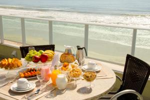 una mesa con comida y vistas a la playa en Marin Château Empreendimentos Turísticos, en Bombinhas