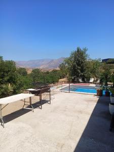 a swimming pool with a table and a picnic table at la casa del cerro in Casas de Batuco