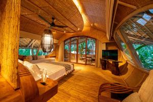 a bedroom with a bed and a tv in a room at Ulaman Eco Luxury Resort in Tabanan