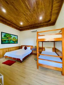 a bedroom with two bunk beds and a wooden ceiling at Phong Nha Dawn Home in Phong Nha +60 photos