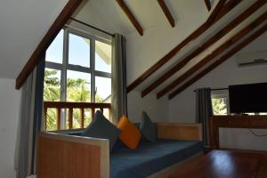a living room with a couch and a large window at La Modestie Guest House in Grand'Anse Praslin