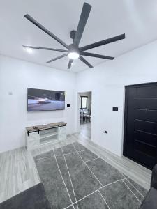 a living room with a ceiling fan and a table at Modern Caribbean retreat 2 in Kingston