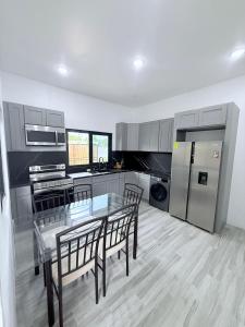 a kitchen with a glass table and chairs in it at Modern Caribbean retreat 2 in Kingston