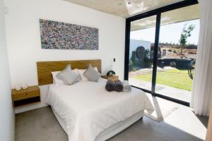 a bedroom with a white bed with a large window at Walvishaai in Stompneusbaai +30 photos