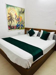 a bedroom with a large white bed with green sheets at Hotel park view in Bathinda