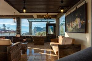 a living room with couches and a large window at Fort WindShire in Nuwara Eliya