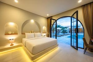 a bedroom with a white bed and a patio at DESAULU VILLAS - Boutique Private Room Pool View in Uluwatu +35 photos